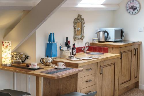 a kitchen with a sink and a microwave at Penbontbren Luxury Bed and Breakfast in Aberporth
