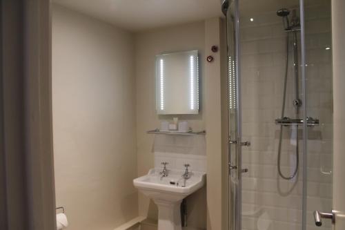 a bathroom with a sink and a shower at The Woolpack Hotel in Tenterden