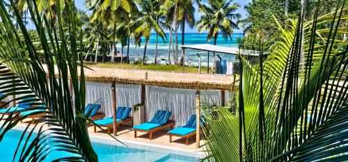 a pool with chairs and the ocean in the background at Pingwe Beach Apartments in Pingwe