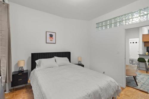 biała sypialnia z łóżkiem i stołem w obiekcie Cozy 1BR in the Upper East Side w Nowym Jorku