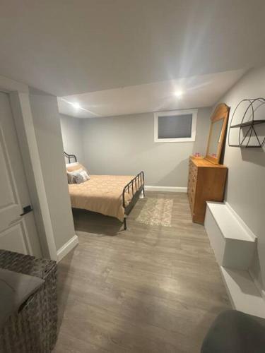 a bedroom with a bed and a dresser in it at Private Basement Suite in Halifax in Halifax