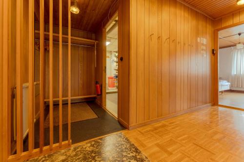 un pasillo vacío con paredes revestidas de madera y una puerta de cristal en The Cookie Store Guesthouse en Tórshavn