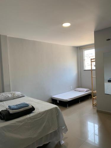 Favela Musique Hostel في ريو دي جانيرو: غرفة بيضاء مع سرير ونافذة