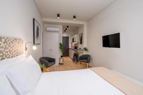 a bedroom with a bed and a desk with chairs at Luxury 101 Studio apartment in central Athens in Athens