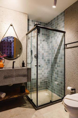 a bathroom with a glass shower and a sink at Pysá Zero Um in São Miguel dos Milagres