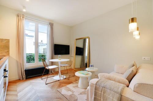 un salon avec un canapé et une table dans l'établissement Suite Deluxe 2 by Les Maisons de Charloc Homes, à Boulogne-Billancourt