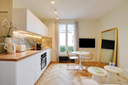 une cuisine avec un comptoir, une table et des chaises dans l'établissement Suite Deluxe 2 by Les Maisons de Charloc Homes, à Boulogne-Billancourt
