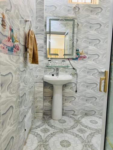 a bathroom with a sink and a mirror at Résidence Mounir in Thiès