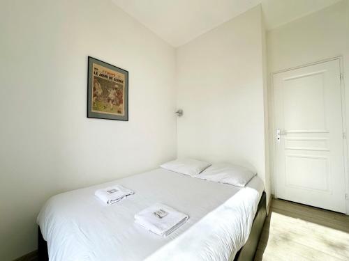 a bedroom with a white bed with two towels on it at Le Midou - Central - Calme - Vue sur Rivière - Fibre in Mont-de-Marsan