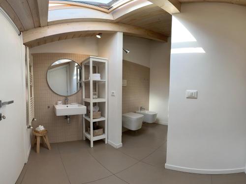 a bathroom with a sink and a mirror and a toilet at Villa Fiorentino in Rossano