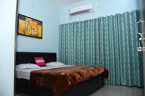 um quarto com uma cama e uma cortina verde em Indra Apartment em Varanasi