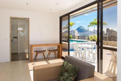a living room with a couch and a table and a pool at Leblon Inn, Ótimo Ap in Rio de Janeiro