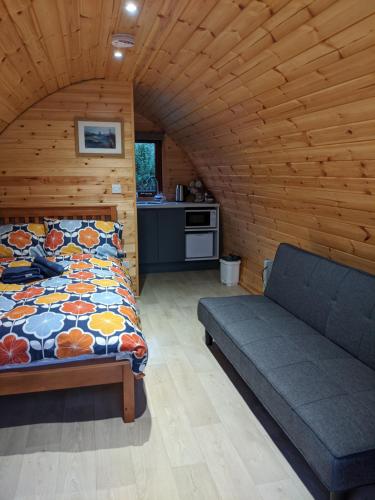 a bedroom with a bed and a couch in a room at Glamping Pod Thady Killynick County Fermanagh in Enniskillen