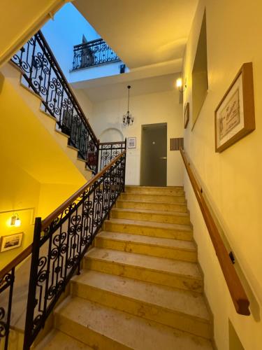 eine Treppe in einem Haus mit gelben Wänden und Holzgeländern in der Unterkunft Hostel Va Bank in Rzeszów