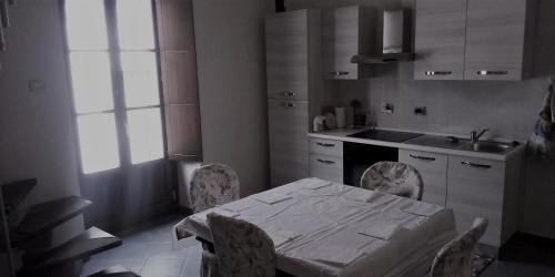 a kitchen with a table and chairs and a sink at Gill's Loft in Saluzzo