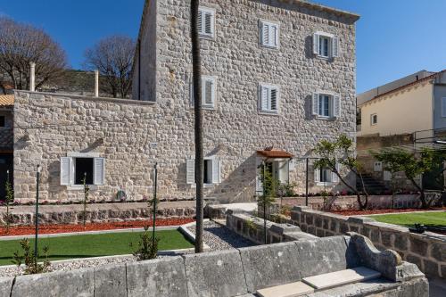 ein Steingebäude mit einer Steinmauer davor in der Unterkunft Apartments Harriet in Dubrovnik