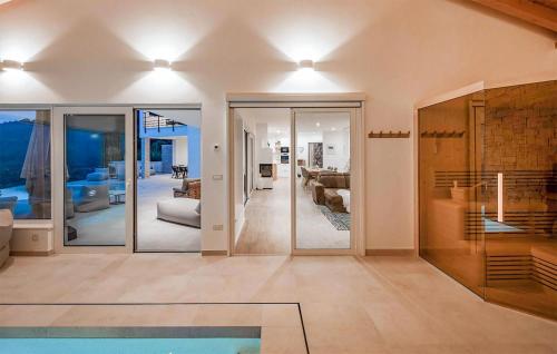 a living room with glass doors and a swimming pool at 3 Bedroom Cozy Home In Bregi in Breza