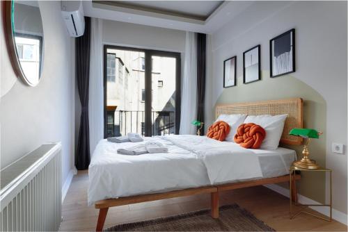 ein Schlafzimmer mit einem Bett mit orangefarbenen Kissen darauf in der Unterkunft Renovu Premium Homes in Cihangir in Istanbul