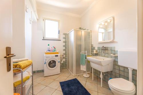 La salle de bains est pourvue d'un lavabo et d'un lave-linge. dans l'établissement Villa Estro del Sud, à Gagliano del Capo