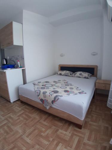 1 dormitorio con 1 cama y suelo de madera en Apartments Snezana en Bar