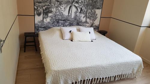 a bedroom with a white bed with two pillows at Gîte Valentine in Aubin