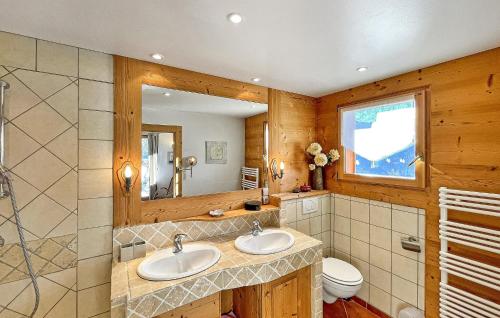 een badkamer met 2 wastafels en een spiegel bij Les Neisieux in Manigod