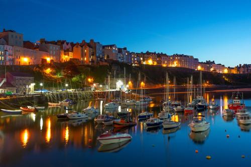 a group of boats docked in a harbor at night at No: 1 The Esplanade Guest Accommodation. in Tenby