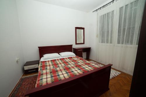 een slaapkamer met een bed met een deken erop bij Flamingo in Virpazar