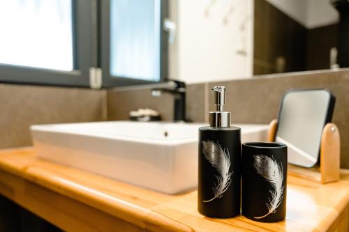 two black bottles on a counter in a bathroom at Panoramic Residence in Borşa