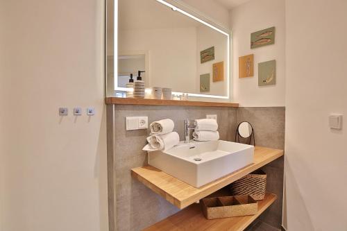 une salle de bains avec un lavabo blanc et un miroir dans l'établissement Residenz Ostseestrand Appartement 14, à Scharbeutz