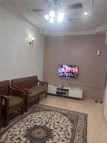 Homestay meranti في كلانغ: غرفة معيشة مع أريكة وتلفزيون