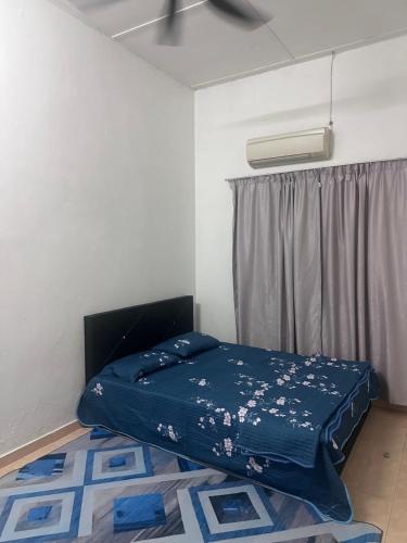 Bett in einem Zimmer mit blauer Bettwäsche und einem Fenster in der Unterkunft Homestay meranti in Klang