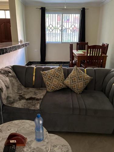 - un salon avec un canapé et une table dans l'établissement Lizzy B Classic Apartments, à Mombasa