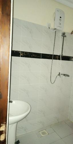 La salle de bains est pourvue d'une douche, de toilettes et d'un lavabo. dans l'établissement Lizzy B Classic Apartments, à Mombasa