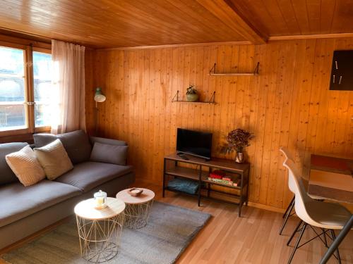 a living room with a couch and a table at Charming, well-equipped Alpine apartment in Kandersteg