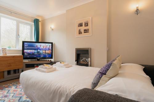 a living room with a large white bed and a tv at Chester Greenway House - Ideal 1 Bedroom Home, EV Charger & Parking - Sleeps 4 in Chester