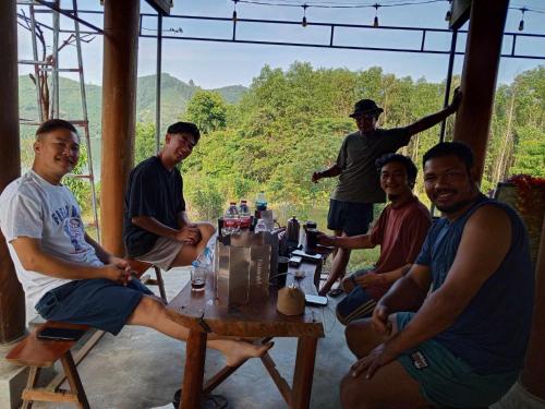 a group of men sitting around a table at Đảo Chè Thanh Chương - Homestay Gió Lào in Trai Ðỏ