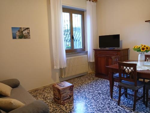 a living room with a couch and a table and a television at Casa Margherita - bike friendly in Verbania