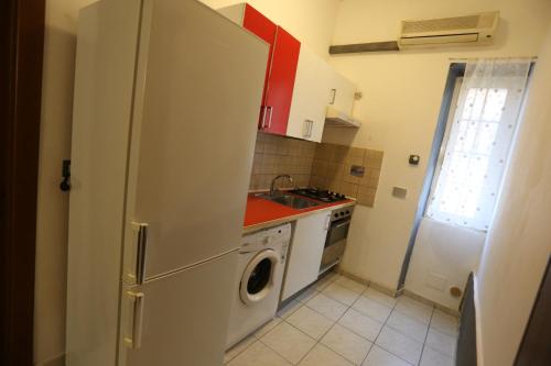 uma cozinha com um frigorífico branco e uma máquina de lavar roupa em House 27 em Fiumicino