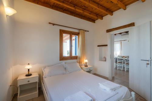 a bedroom with a white bed and a window at Maria's Village Two Bedroom House 1 in Aliki