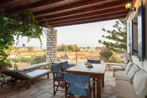 an outdoor patio with a wooden table and chairs at Maria's Village Villa Anemomylos in Aliki