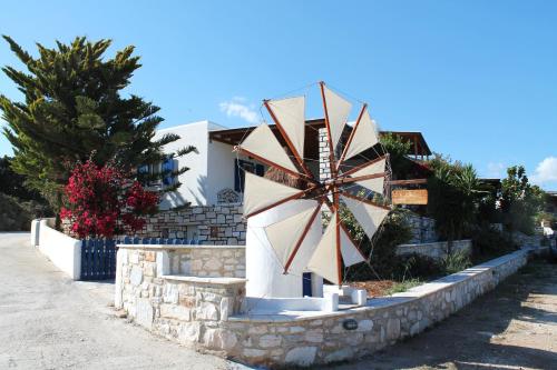 a large windmill sitting on the side of a building at Maria's Village Villa Anemomylos in Aliki