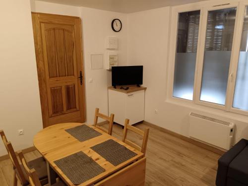 Zimmer mit einem Tisch und einem TV sowie einem Tisch und Stühlen in der Unterkunft Appartement T2 privé proche gare in Marseille
