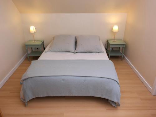 a bedroom with two end tables and a bed at Maison près de la plage et de la thalasso in Roscoff