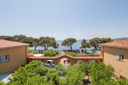 einem Luftblick auf ein Gebäude mit Bäumen und dem Meer in der Unterkunft Logis Hotel Le Provencal in Les Issambres