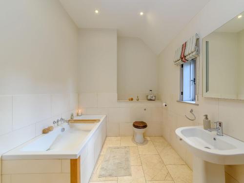a white bathroom with two sinks and a toilet at Tull in Dyrham