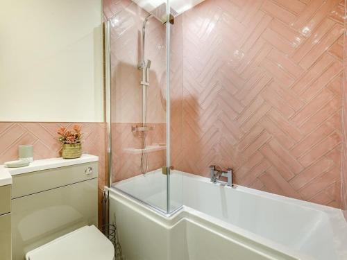 a bathroom with a shower and a tub and a toilet at Pomeroy in Spilsby