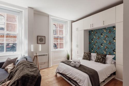 a bedroom with a bed and two windows at Covent Garden Stay in London
