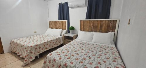 - une chambre avec 2 lits dans une chambre d'hôtel dans l'établissement Discovery Beach Apartments, à Aguada