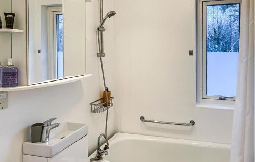 y baño con bañera blanca y lavamanos. en Gorgeous Apartment In Hyltebruk With Kitchen en Hyltebruk